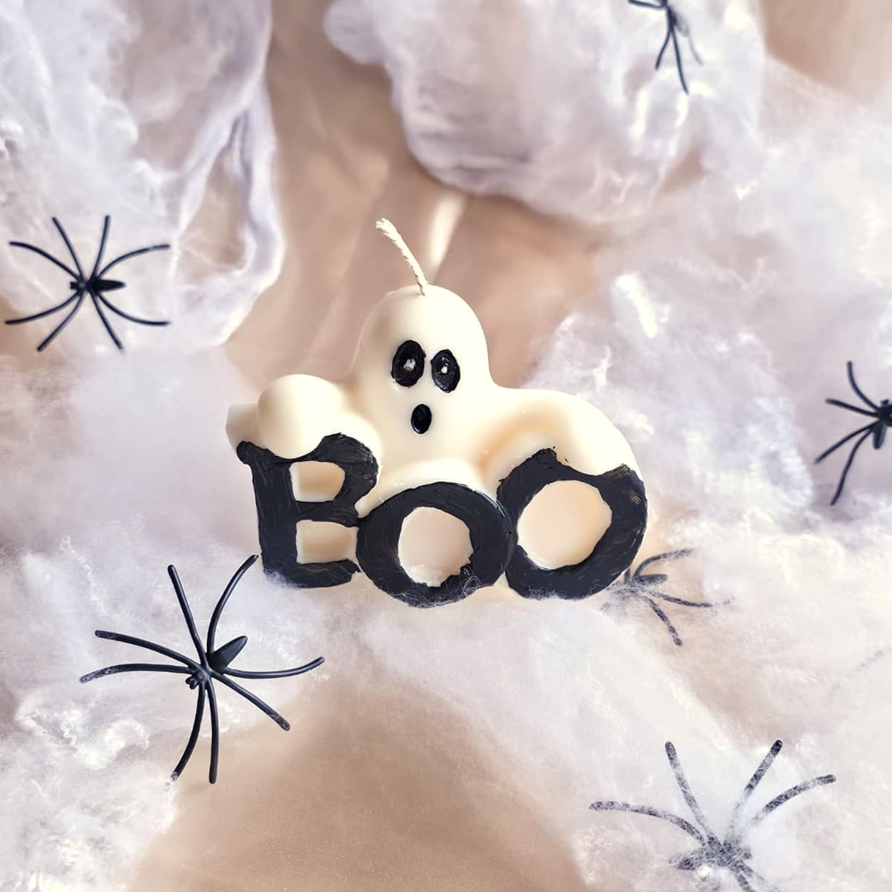 BOO — a ghost candle leaning over hand-painted lettering