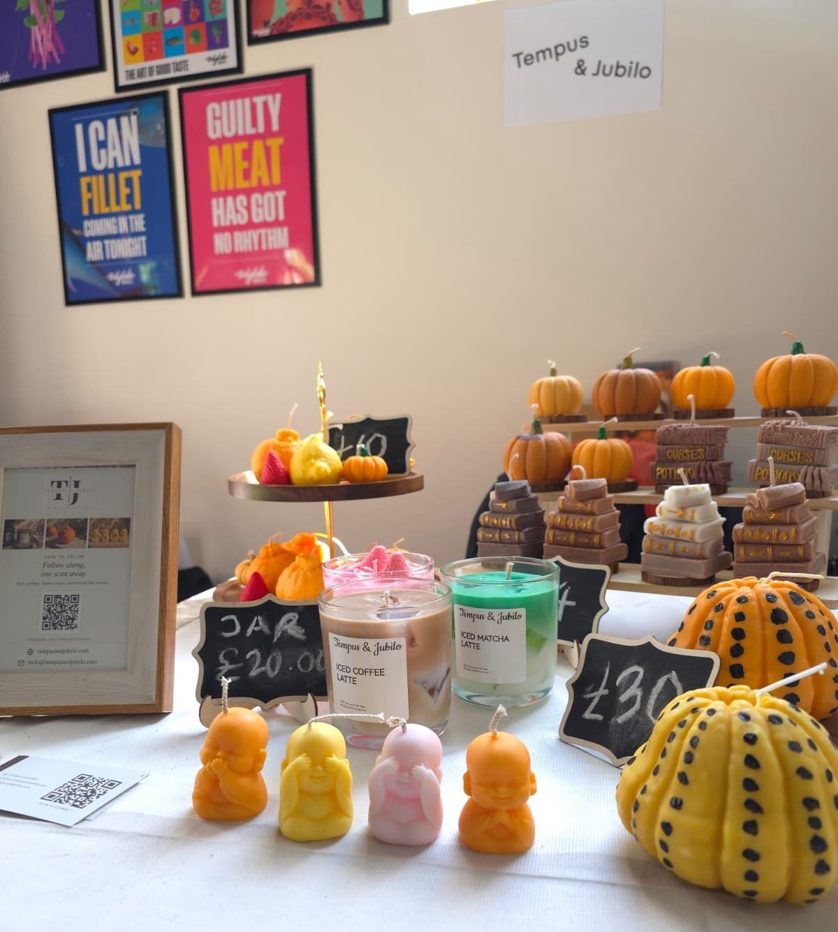 The Tempus & Jubilo table at the Food Art Fair — monk candles, pumpkins, book-stack candles and the café latte jars
